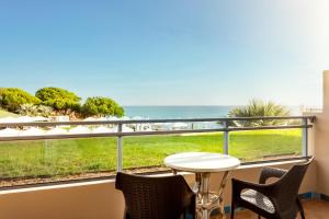 a balcony with a table and chairs and a view of the ocean at Grande Real Santa Eulalia Resort & Hotel Spa in Albufeira