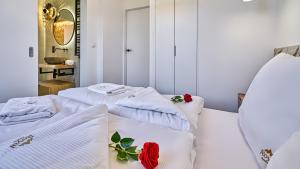 two beds in a room with white towels and red roses at Apartamenty Mariental Boutique - przy wyciągu - by Royal Aparts in Szklarska Poręba