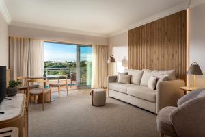 a living room with a couch and a table at Grande Real Santa Eulalia Resort & Hotel Spa in Albufeira