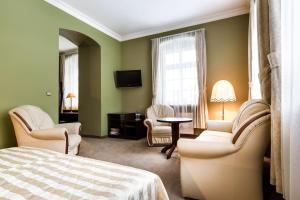 1 dormitorio con 1 cama, sillas y TV en Pałac Spiż koło Karpacza, en Karpacz