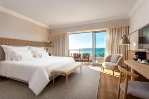 a hotel room with a large bed and a large window at Grande Real Santa Eulalia Resort & Hotel Spa in Albufeira