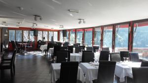 a dining room with tables and chairs and windows at Le Relais de Monti in Menton