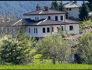 a large white house in the middle of a field at Къща за гости МЕЧА СТЪПКА in Gela