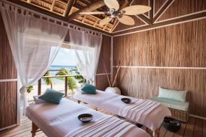 two beds in a room with a view of the ocean at Veranda Pointe Aux Biches Hotel & Spa in Trou aux Biches +33 photos