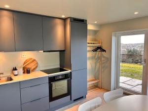 a kitchen with black and white appliances and a table at Apartment with garden and sea view in Haugesund