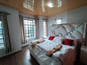 a bedroom with a large bed with red pillows at 4Br Beautiful Mansion Mombasa rd in Nairobi