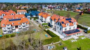 an aerial view of a large house with orange roofs at Dębki Playa Apartments in Dębki