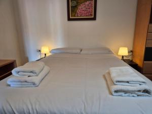 a bedroom with a large white bed with towels on it at 14A05 Apartamento con vistas in Lastres