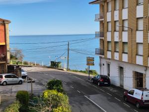 an empty street next to a building and the ocean at 14A05 Apartamento con vistas in Lastres