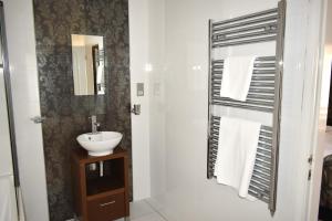 un baño con lavabo y espejo en Donington Manor Hotel, en Castle Donington 60 fotos más