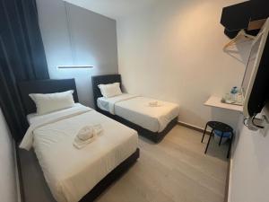 una piccola stanza con due letti e un tavolo di Self Check-In - Havona Hotel Plentong a Johor Bahru
