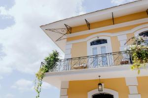 a yellow and white building with a balcony at AmazINN Places Hotel Boutique Casa Marroqui in Panama City