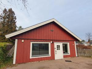 a red barn with a door and a window at 3 rum och kök 4 bäddar in Oskarshamn