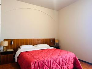 a bedroom with a bed with a red blanket at Hotel Business in Pontenure +5 photos