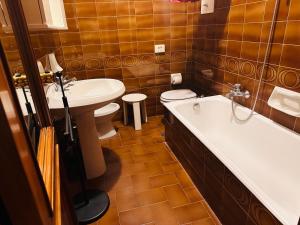 a bathroom with a tub and a toilet and a sink at Hotel Business in Pontenure