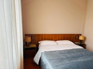 a bedroom with a bed and two night stands with lamps at Hotel Business in Pontenure