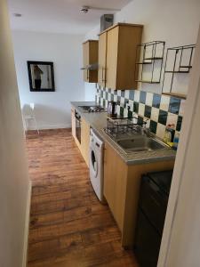 a kitchen with a sink and a washing machine at Train Station Apartments in Crewe