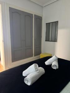 a bedroom with a bed with towels on it at Apartamento Jardín de San Feliz / Fontán in Oviedo