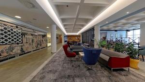 eine Lobby mit Sofas, Stühlen und Gemälden an der Wand in der Unterkunft Hampton By Hilton Gdansk Old Town in Danzig