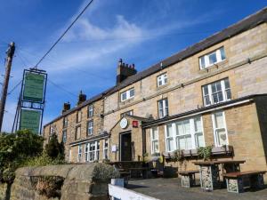 an old brick building with a clock on it at Rose Hip Cottage in Hexham