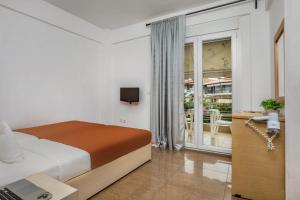 ハニオティスにあるNikiforos Apartmentsのベッドと電話付きの机がある寝室