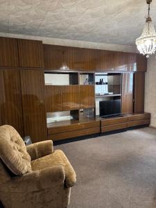 a living room with a chair and a television at Apartment near Opera Hause in Dnipro +4 photos