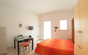 a bedroom with a bed and a table and a desk at Imperatrice Rent Room - Porto Cesareo in Torre Squillace