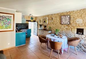 een keuken en eetkamer met een tafel en stoelen bij Le Chevrefeuille chambres d'hotes et gîtes de charme in Meyrals
