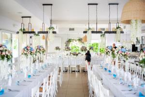 a bride and groom stand in front of their tables at a wedding at Dębki Playa Apartments in Dębki