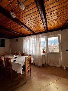 a dining room with a table and a large window at Dor de munte in Măgura +22 photos