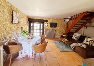 een woonkamer met een tafel en een bank bij Le Chevrefeuille chambres d'hotes et gîtes de charme in Meyrals
