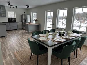 a dining room with a table and green chairs at Törreby 230 in Jörlanda
