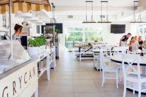 a restaurant with white tables and white chairs at Dębki Playa Apartments in Dębki