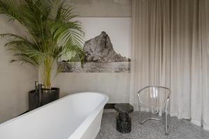 a bathroom with a white tub and a plant at SCALA by Valletta Vintage in Valletta