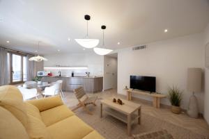 a living room with a yellow couch and a table at Apartamento Turístico Royal, by CartagenaSpain in Cartagena