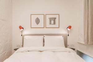 a bedroom with white walls and a bed with two lamps at SCALA by Valletta Vintage in Valletta