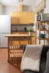 a kitchen with a wooden table and a refrigerator at Alma de Zahara in Zahara de los Atunes