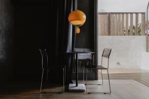 a black room with two chairs and a table with a lamp at SCALA by Valletta Vintage in Valletta