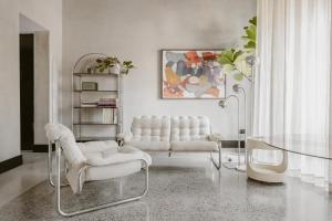 a living room with two white chairs and a table at SCALA by Valletta Vintage in Valletta