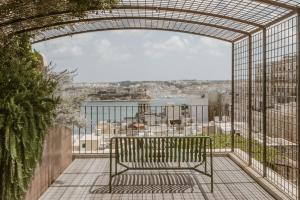 a bench on a balcony with a view of the city at SCALA by Valletta Vintage in Valletta