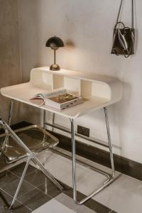 a white desk with a book and a lamp on it at SCALA by Valletta Vintage in Valletta