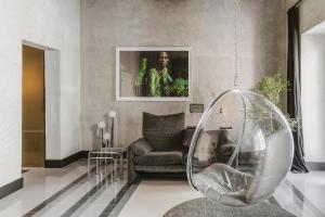 a living room with a chair and a mirror at SCALA by Valletta Vintage in Valletta