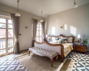 a bedroom with a large bed with a bench at LohonoStays Calisto Villa C in Siolim +9 photos