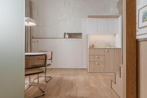a kitchen with white cabinets and a table and chairs at SCALA by Valletta Vintage in Valletta
