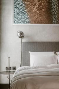 a bedroom with a bed and a painting on the wall at SCALA by Valletta Vintage in Valletta