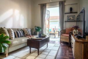 a living room with a couch and a table at LohonoStays Calisto Villa C in Siolim