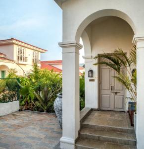 an archway leading to a house with a door at LohonoStays Calisto Villa C in Siolim