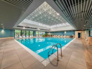 a large indoor swimming pool with a glass ceiling at Novotel Gdańsk Marina in Gdańsk