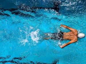 a woman swimming in the water with a ball at Novotel Gdańsk Marina in Gdańsk
