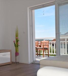 een woonkamer met een glazen schuifdeur naar een balkon bij Apartments Zelic in Vodice